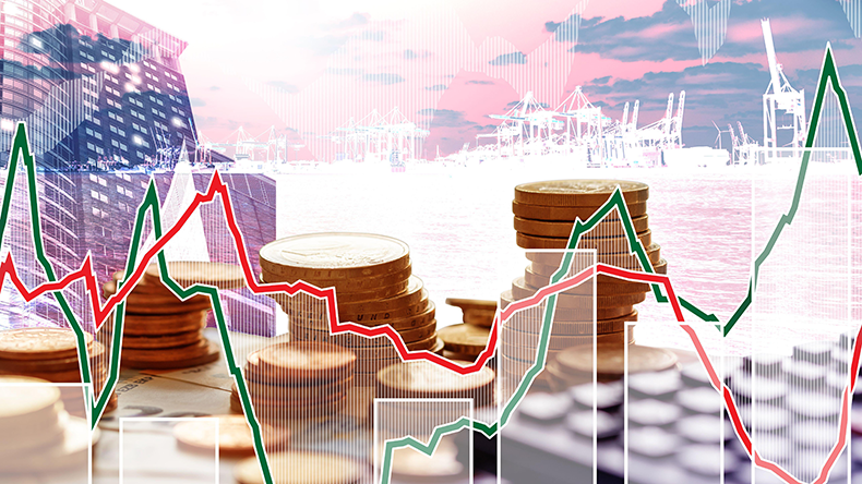 Euro coins in pile on Euro banknotes with calculator and charts in background