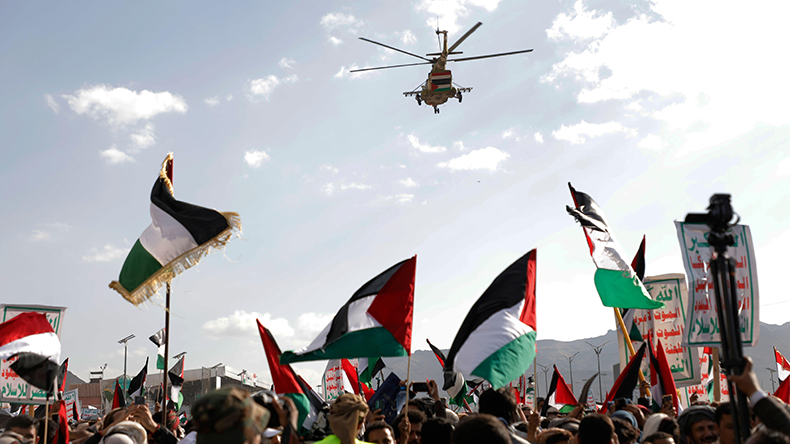 Sanaa, Yemen: A helicopter flies, as Houthi supporters rally